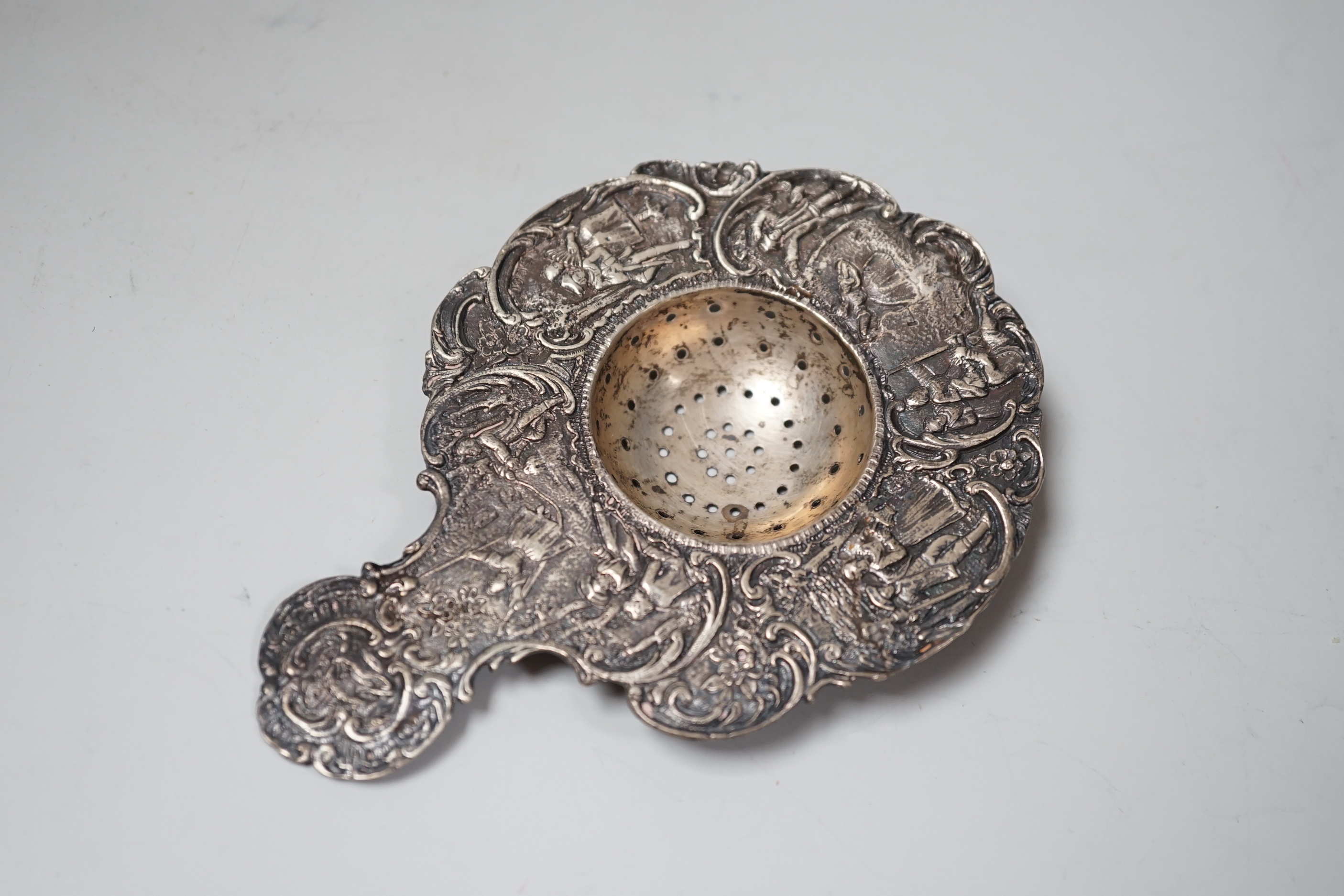 A late Victorian silver tea strainer, import marks for London, 1900 and a pierced silver plated bowl.